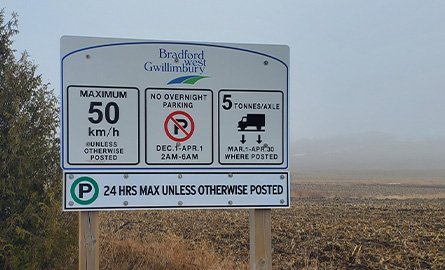 BWG traffic sign on the side of the road, illustrating maximum municipal speed, winter parking restrictions, load limits, and 24 hour parking restrictions.
