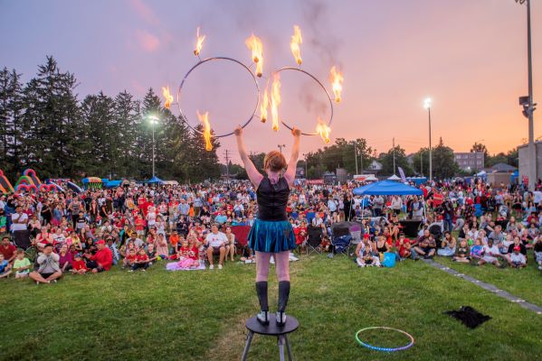 fire performer with hula hoops in front of crowd at event