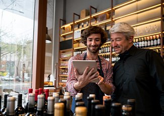 Two liquor sales business owners looking at a tablet