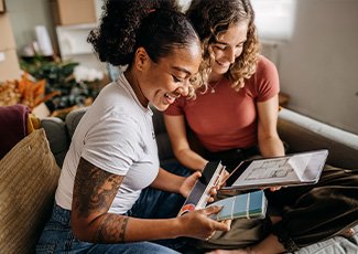 Couple selecting a colour from a colour swatch, and looking at a floorplan on their tablet