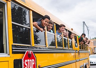 Kids on bus hanging outside of windows