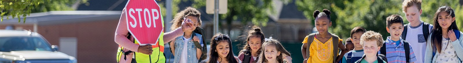 kids crossing to school with a stop sign