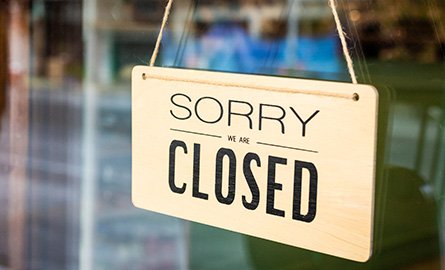 Sign on retail store reading "sorry, we are closed"