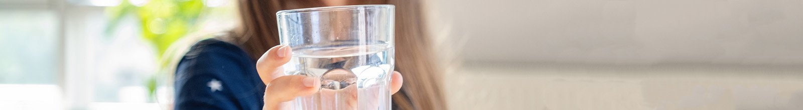 Close up photo of young girl holding a glass of drinking water