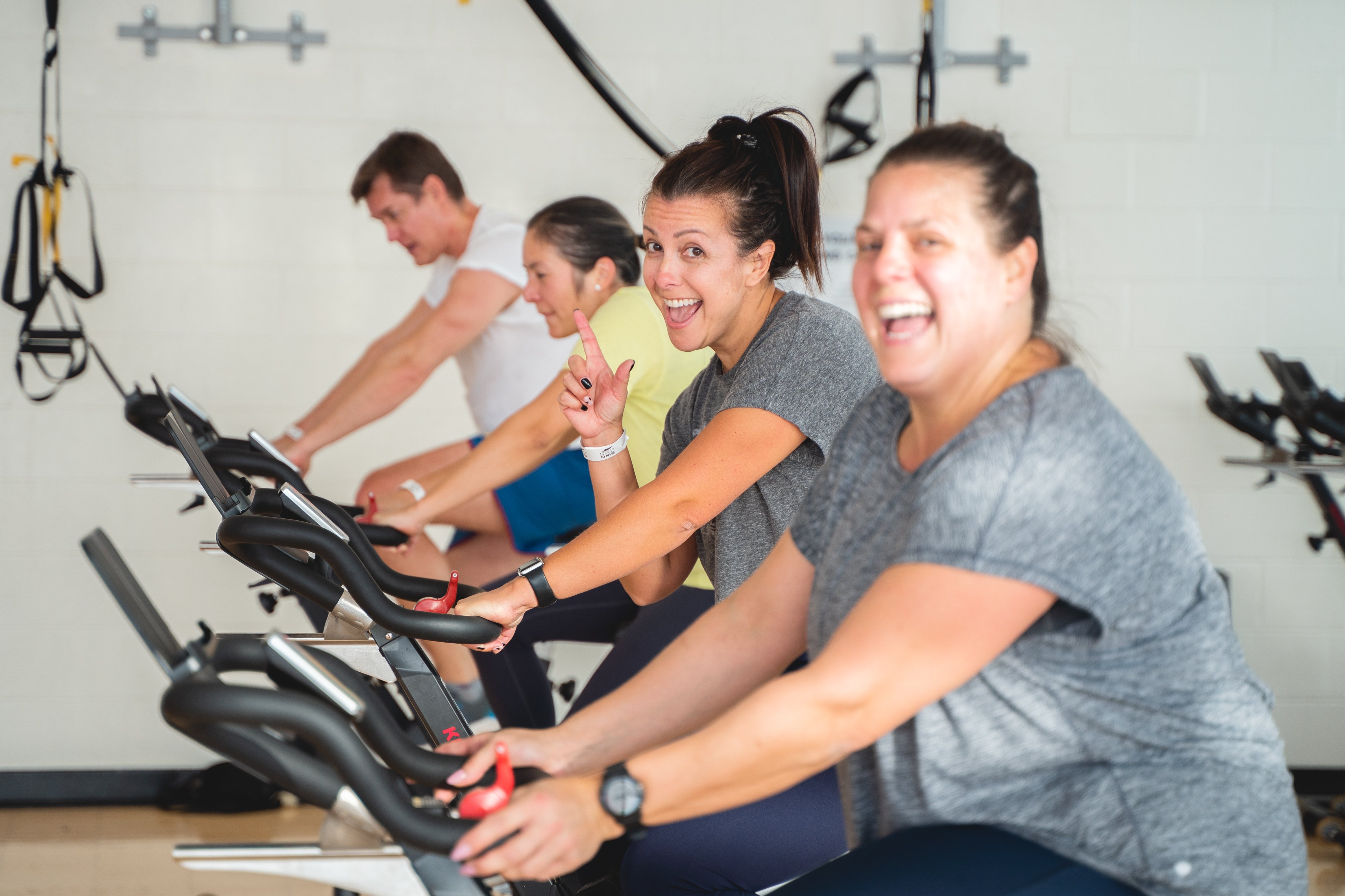 Participants smiling while in a spin class