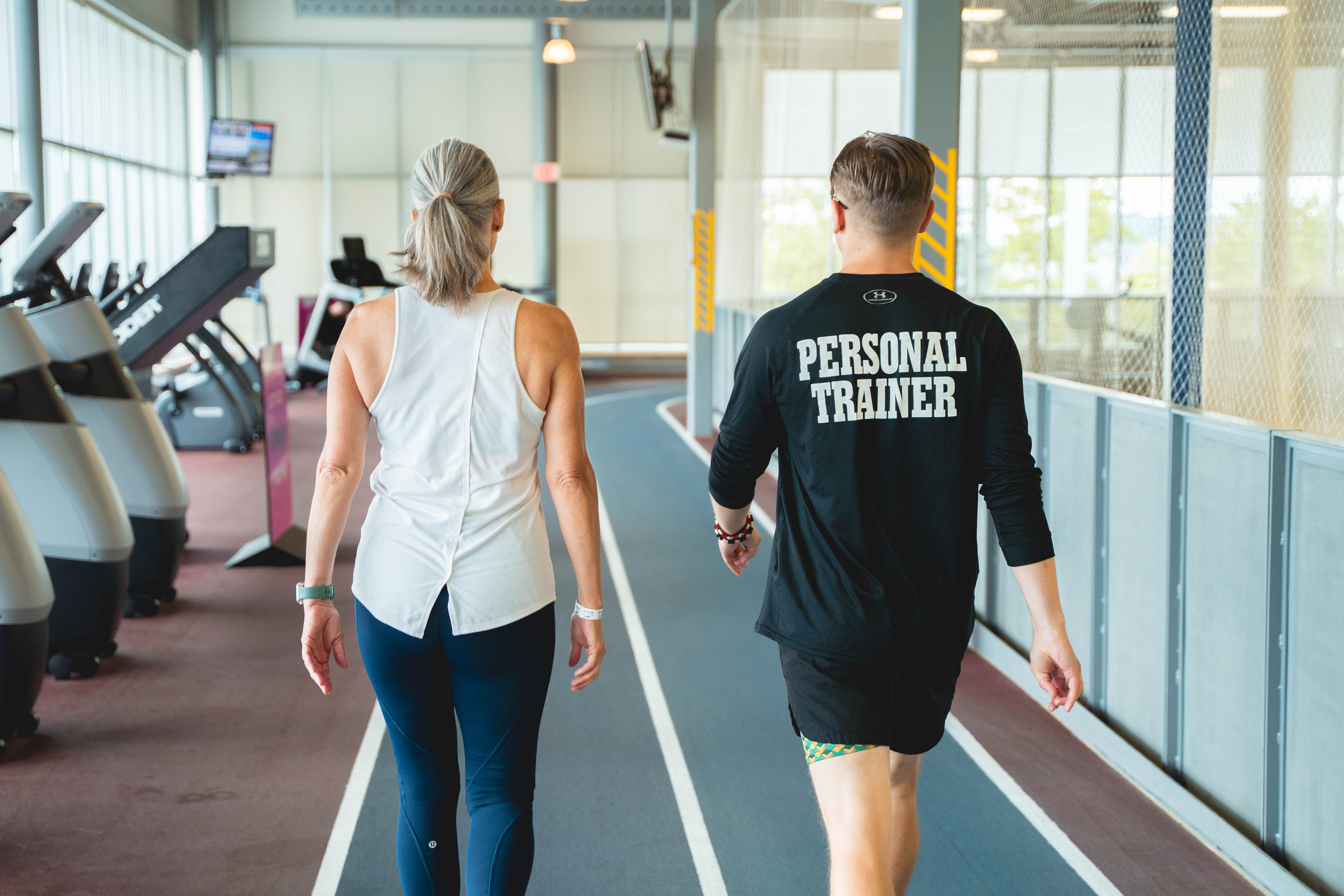 personal trainer and client walking on track