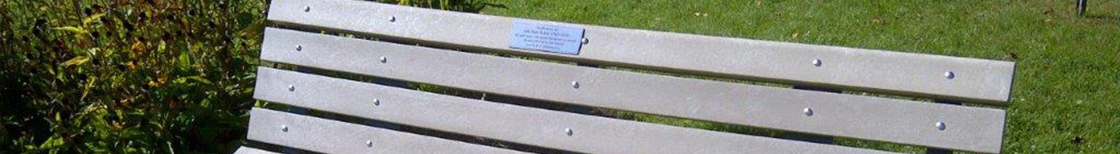 Up close photo of park bench in BWG with a commemorative plaque