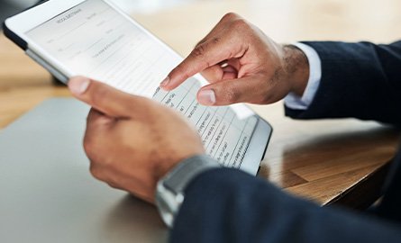 Close up of a person completing a form on a tablet