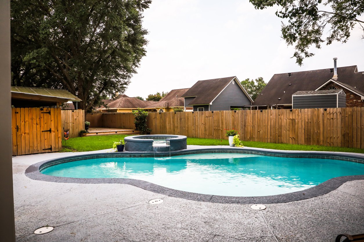 Backyard with swimming pool and wooden fence