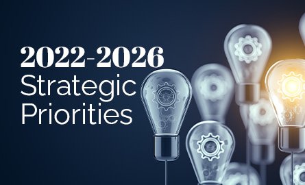 Background photo of lightbulbs with gears inside, one bulb is lit. Overlay text reading "2022-2026 Strategic Priorities"