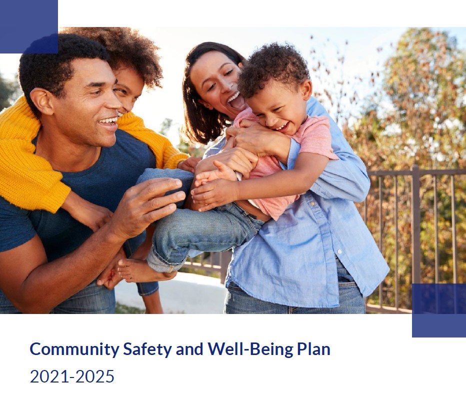 A family of four smiling and laughing outdoors