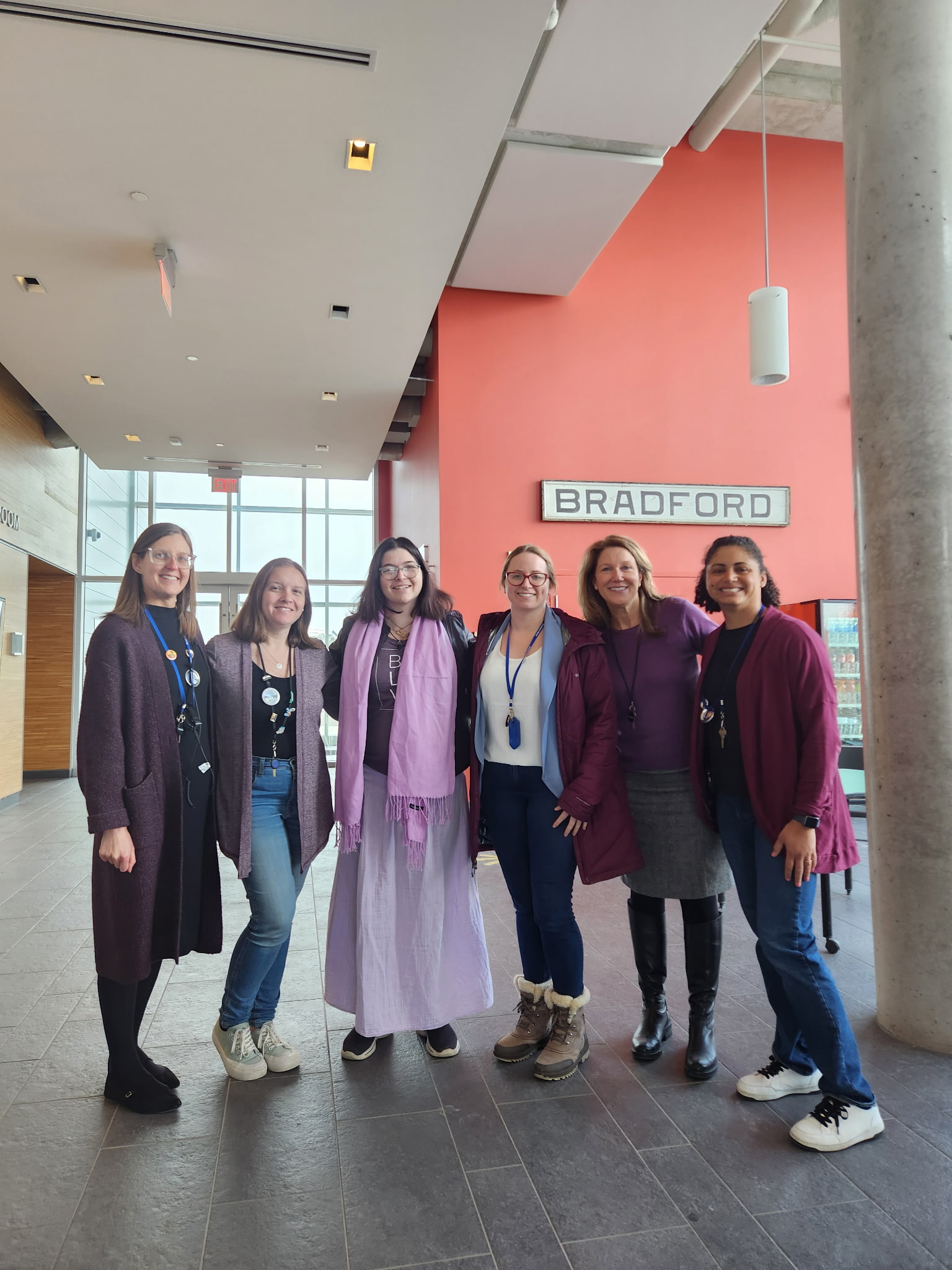 GROUP OF WOMEN STANDING WEARING PURPLE