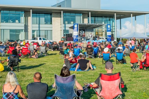 Community members from BWG sitting at the Library West Lawn during a concert at the 2022 Music in the Park event