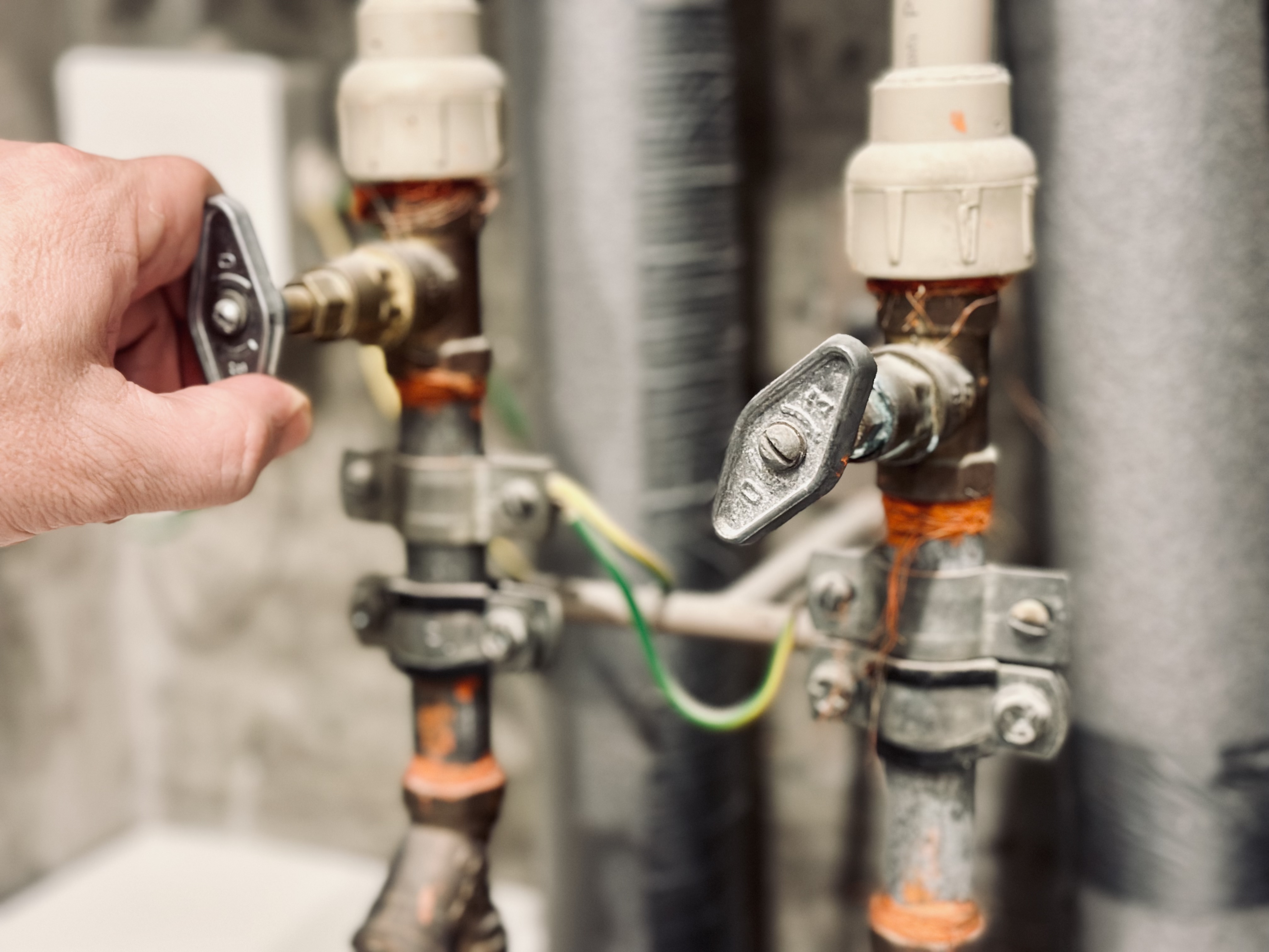 A hand turning off water valve