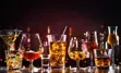 Several alcoholic beverages lined up along a bar counter