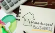 Partial vie of calculator, eye glasses, writing utensils, and a sketchbook with a drawing of a home and the words "Home-based Business"