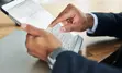 Close up of a person completing a form on a tablet